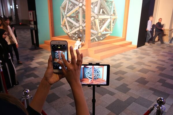 Spectators interacting with the mural and observing the augmented reality effects